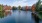 a body of water with trees and buildings around it