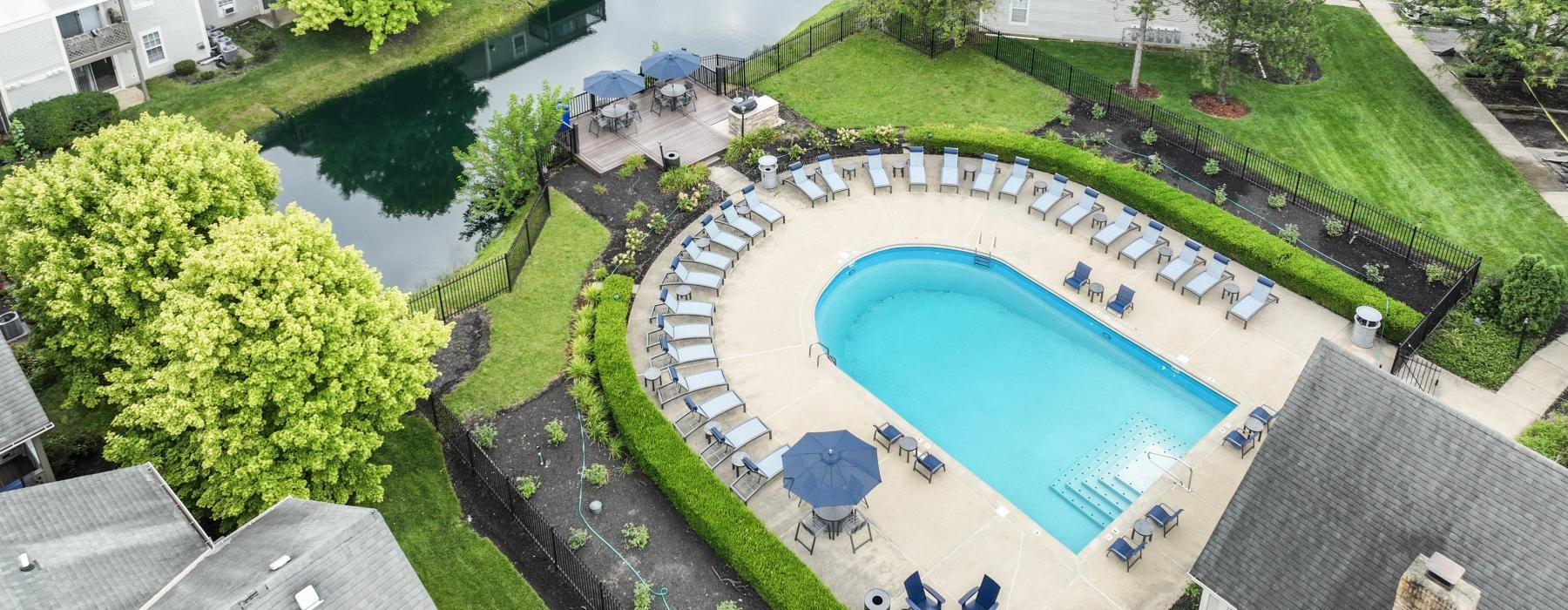 a pool surrounded by buildings and trees