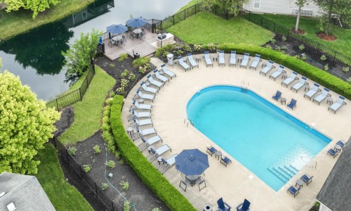 a pool surrounded by buildings and trees