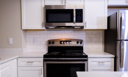 a kitchen with white cabinets and stainless steel appliances
